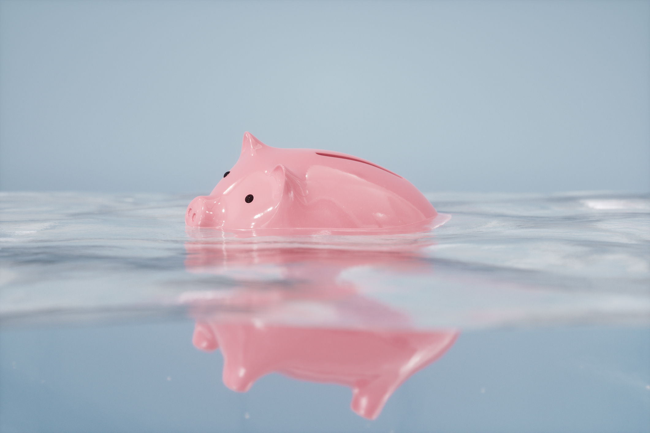 Sinking piggy bank in the water.